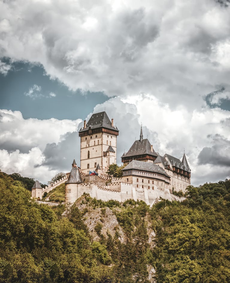 White and Black Concrete Castle on Mountain Under White Clouds