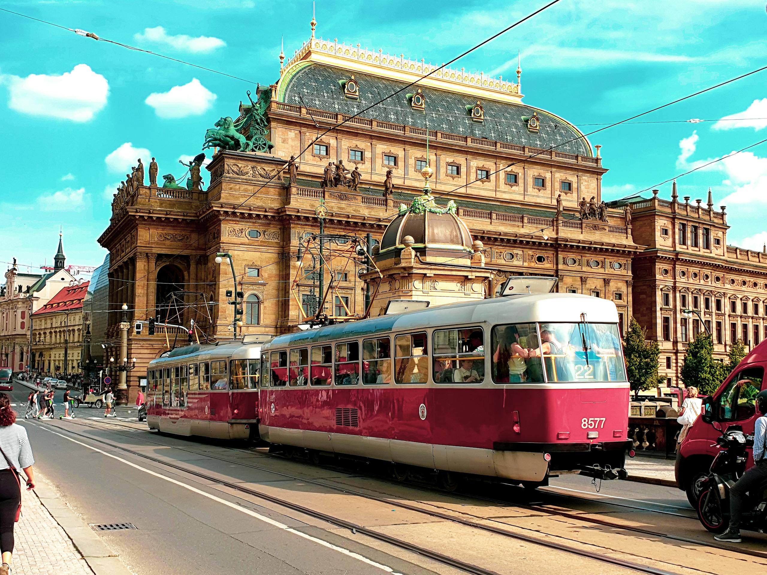 Red tram passes by the iconic National Theatre in the heart of Prague, Czechia.