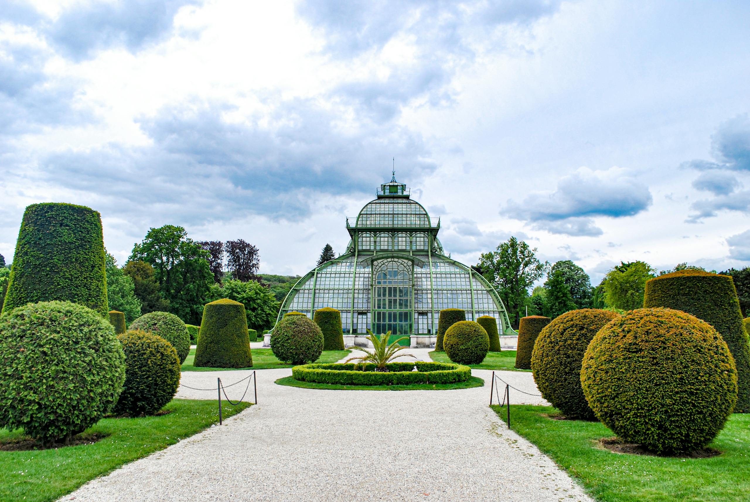 Stunning glass conservatory surrounded by manicured gardens in Vienna, Austria.