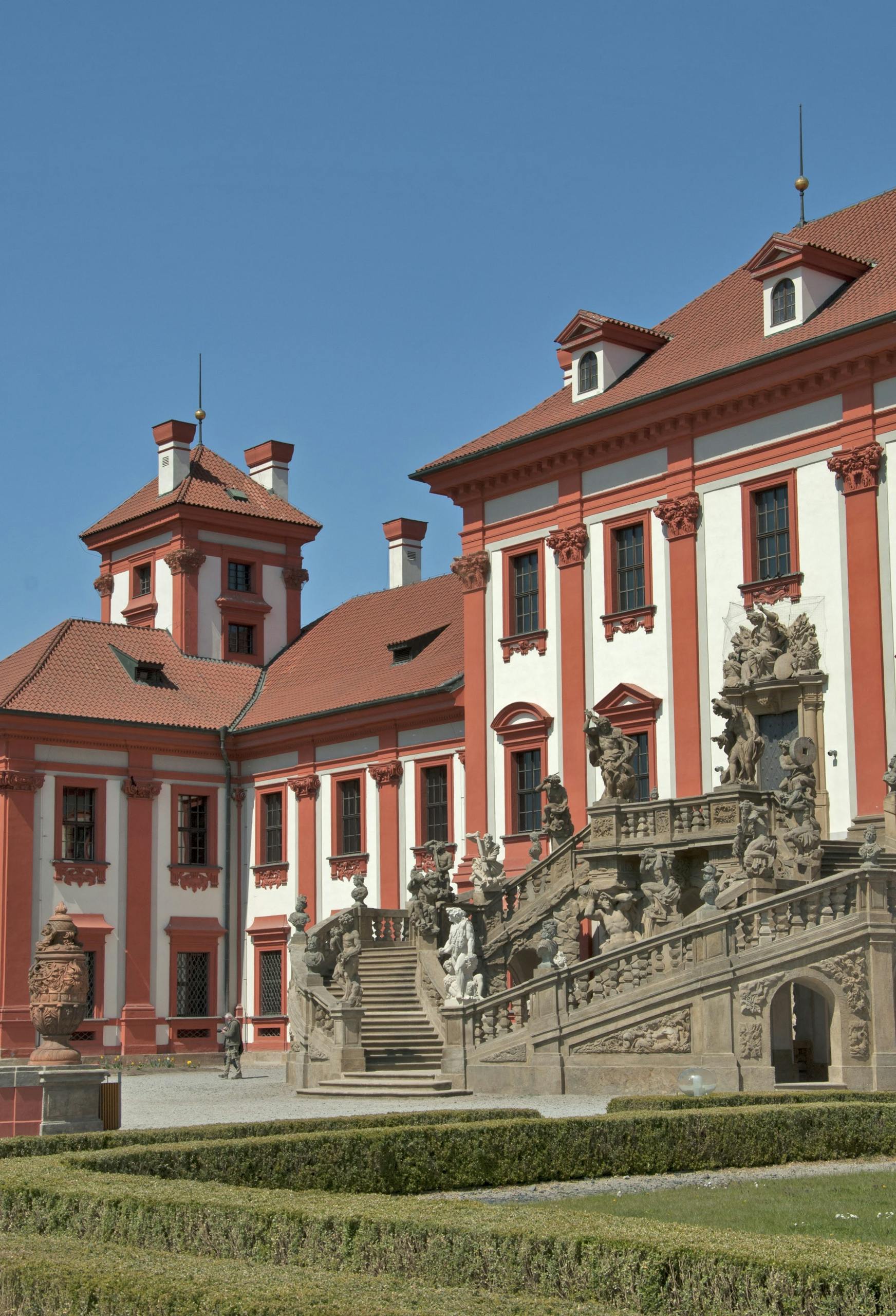 Troja Palace in Prague with beautiful Baroque architecture under a clear blue sky.